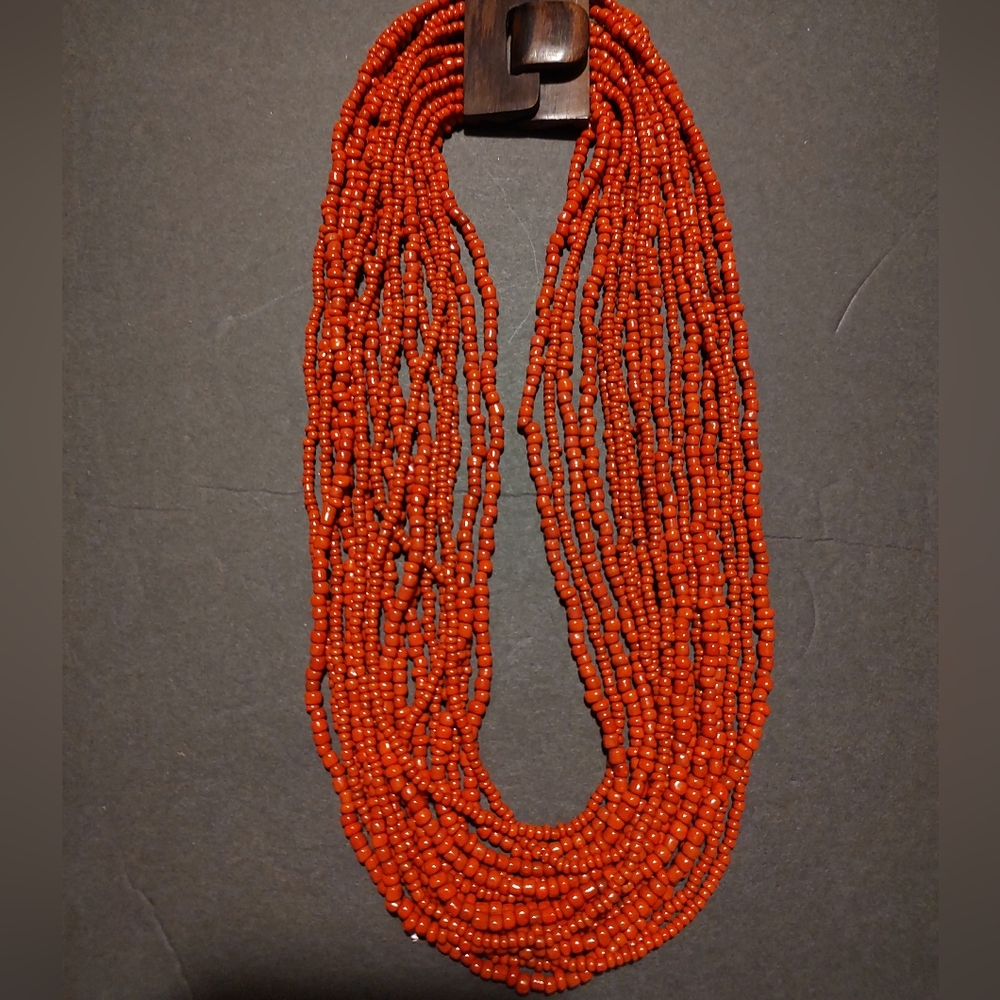 Coral beaded necklace with dark wood buckle clasp